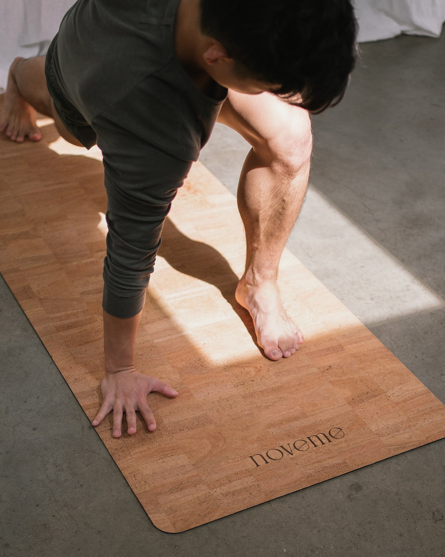 Man practicing yoga on a Noveme cork yoga mat