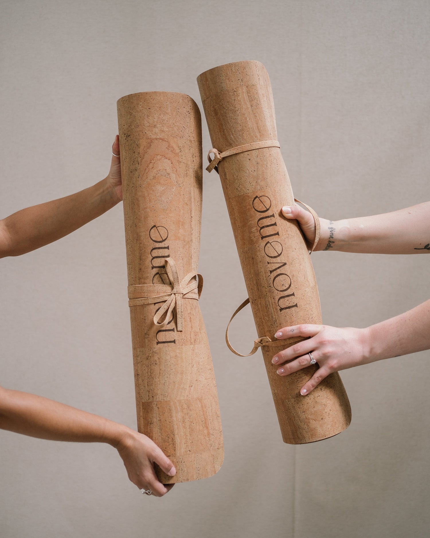 Two yogis holding a November cork yoga mat each