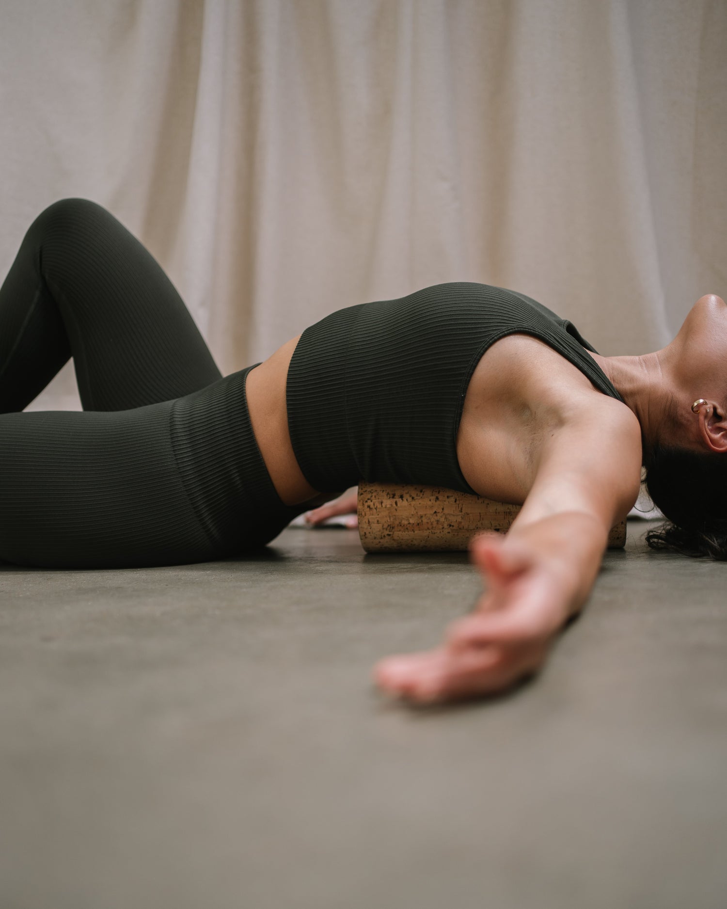 Woman massaging her back with a Noveme cork roller