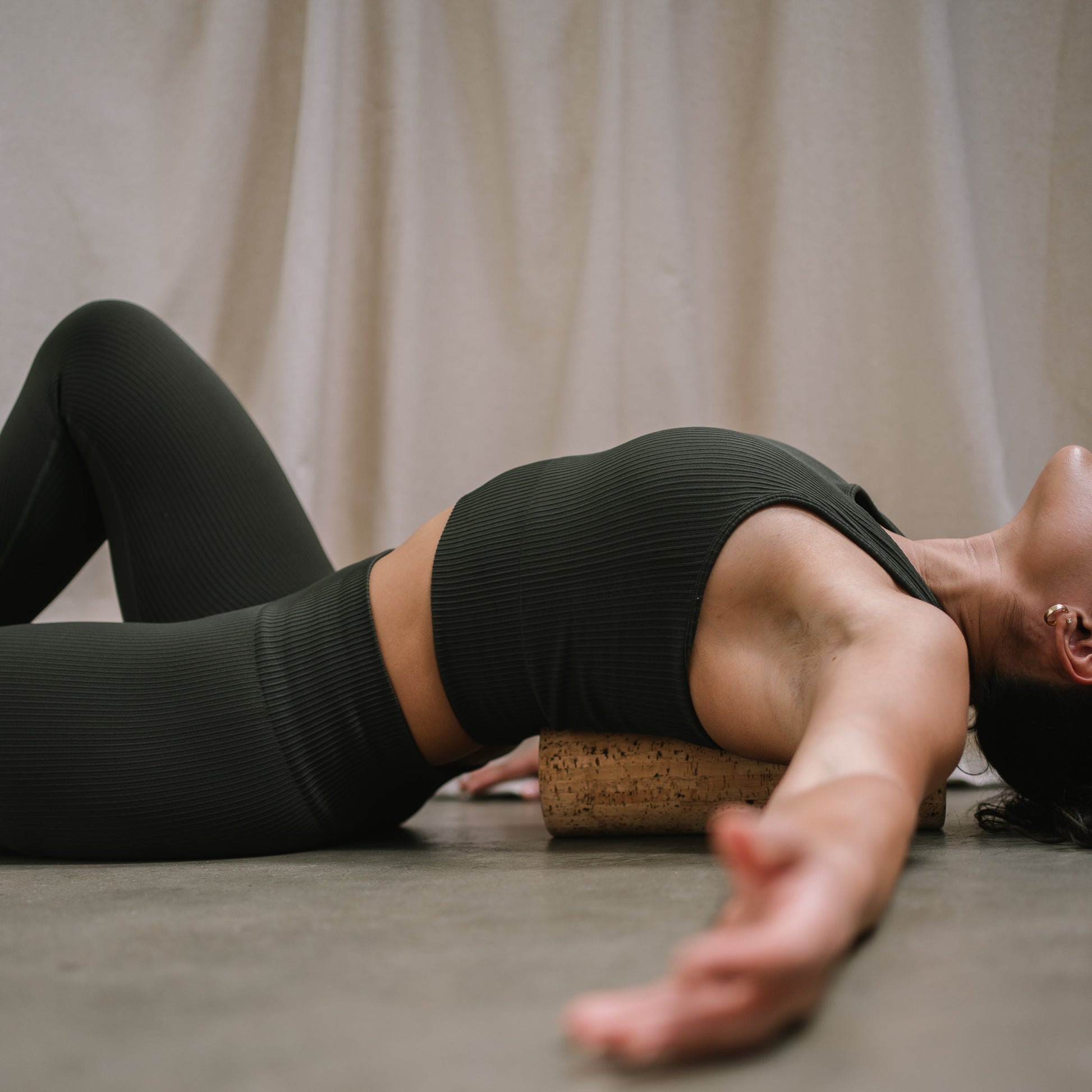 Woman using a Noveme Cork Roller to massage her back