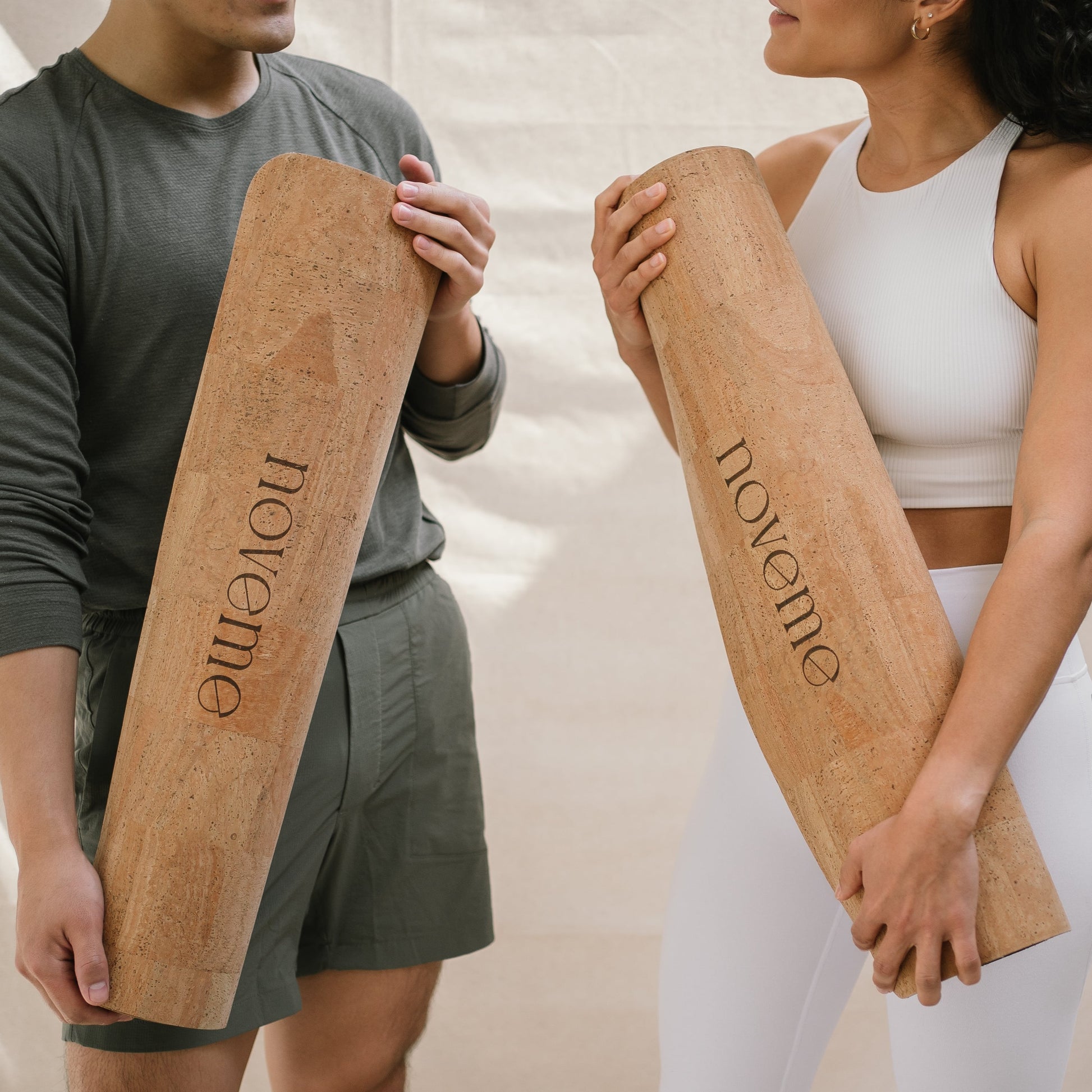 a man and a woman each holding a Noveme Cork Yoga Mat