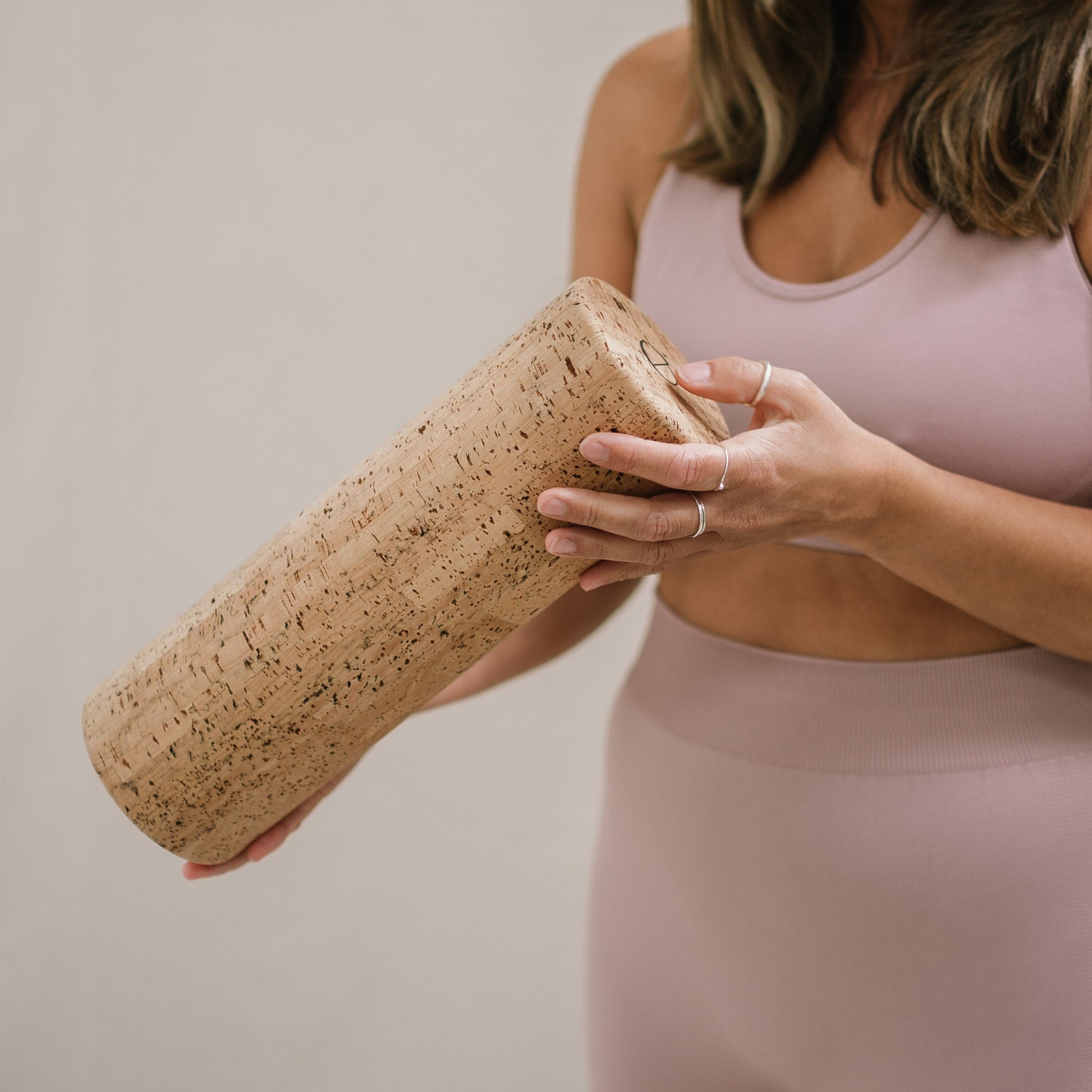 Woman holding a Noveme Cork Yoga Block
