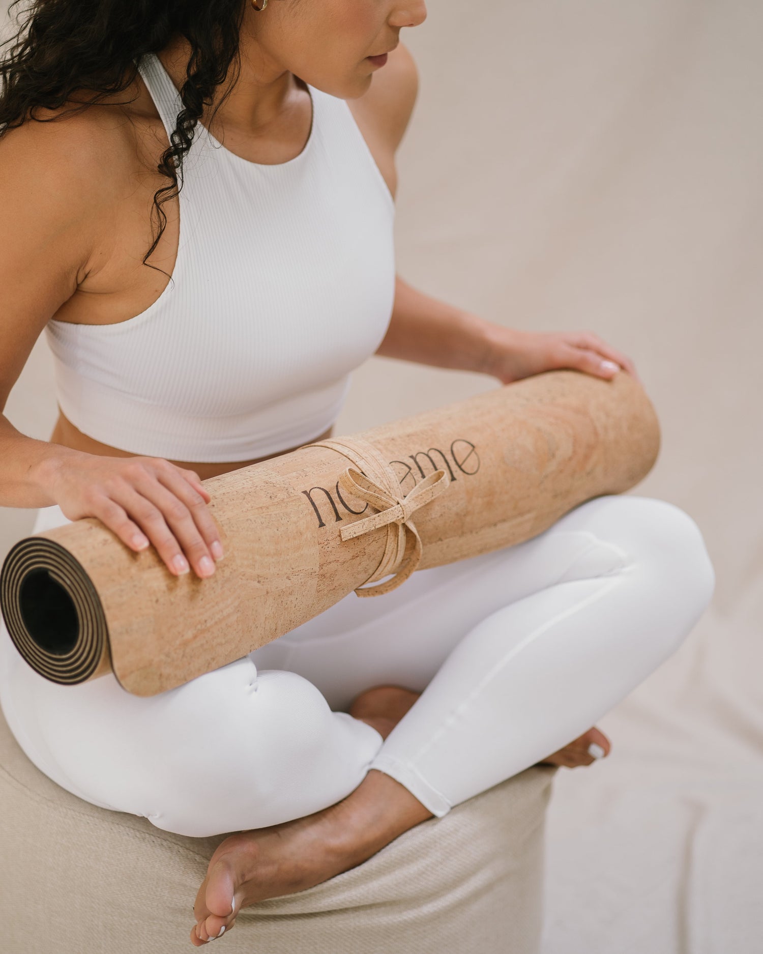 Yogi with a Noveme cork yoga mat on her lap