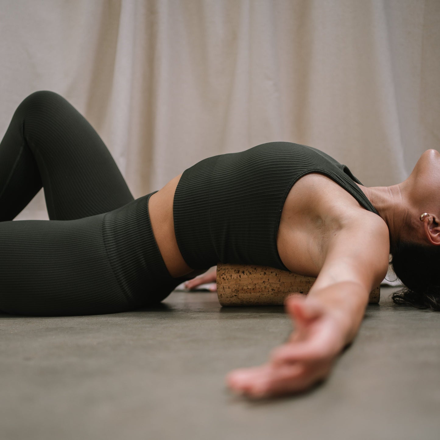 model using a noveme cork roller to massage her back